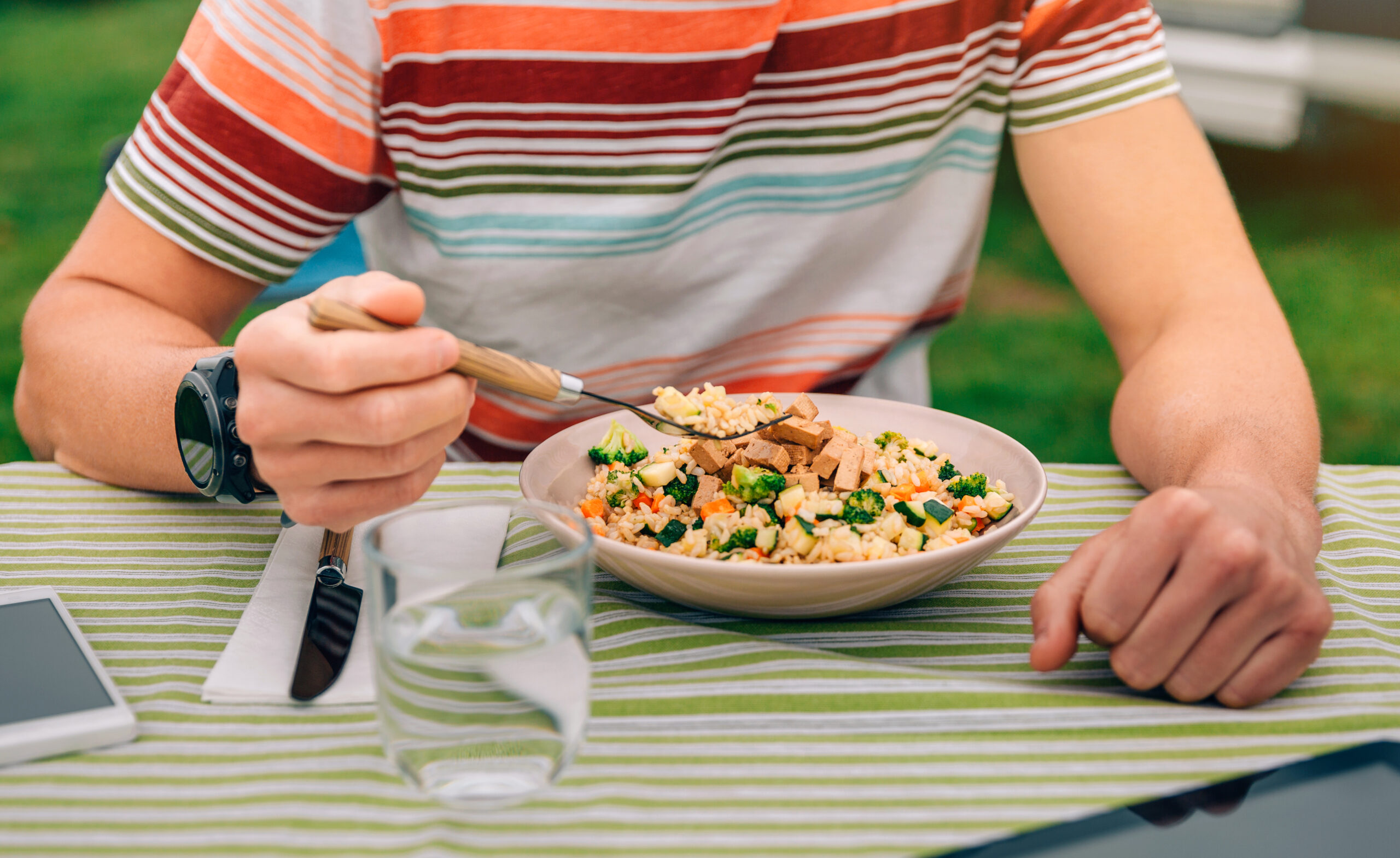 Unrecognizable man eating vegan food outdoors