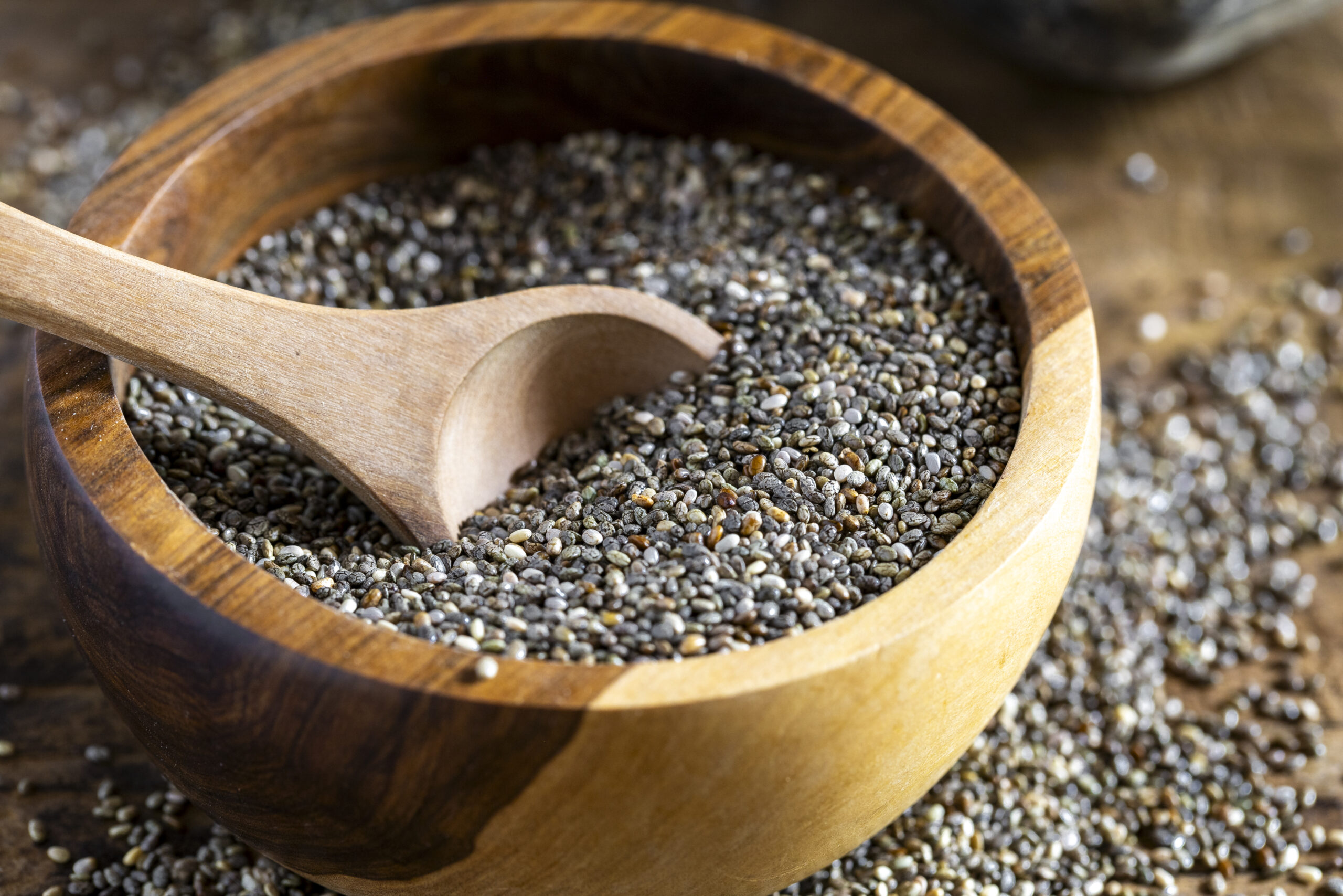 Pile of chia beans in a wooden container, close-up image